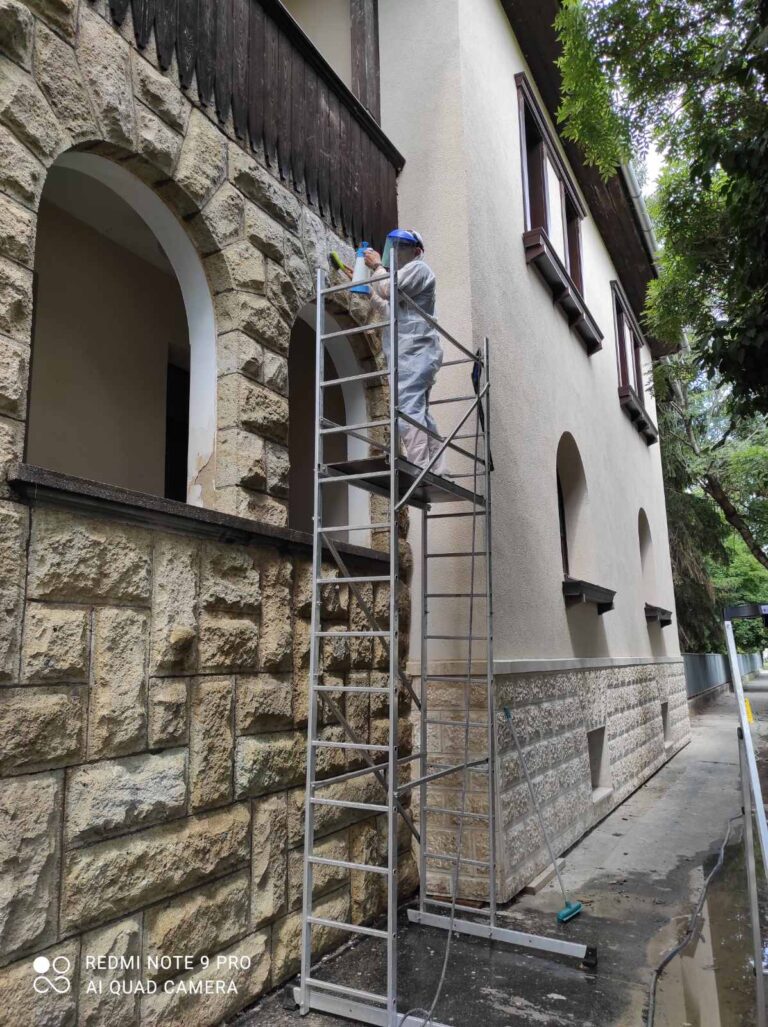 Kézi kefés kőtisztítás vegyszeres előkezelés után, a keleti homlokzaton