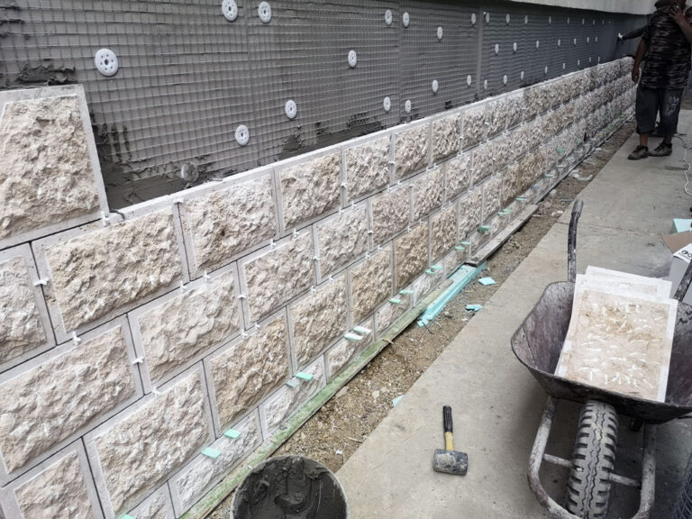 Hőszigetelt homlokzatra ragasztott lábazati kőburkolat kivitelezés közben